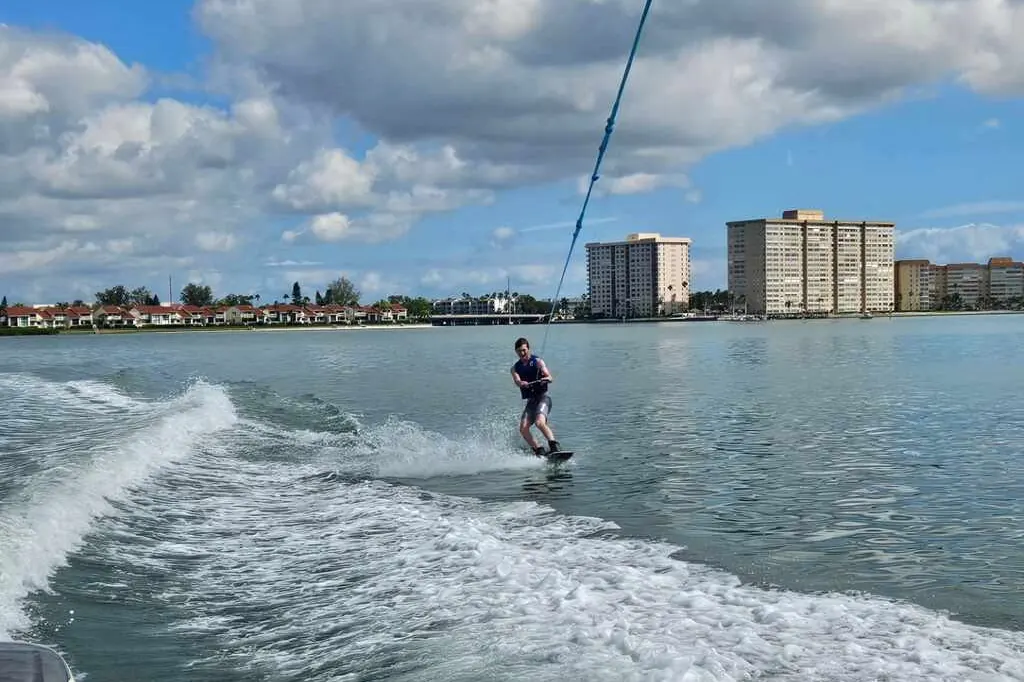Guest standing up on a wakeboard behind a boat near Gulfport