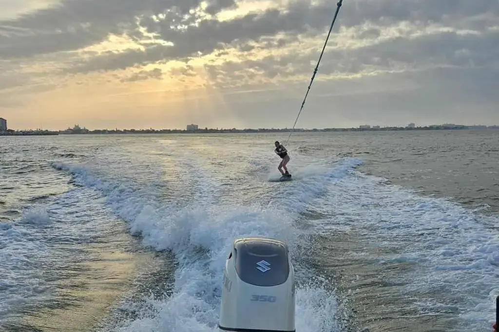 Guest tubing behind a private boat under cloudy skies