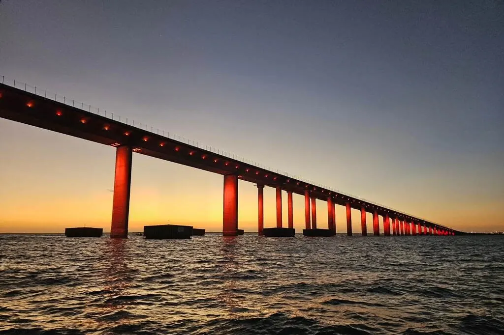 Sunset glowing behind a bridge seen from a boat on Tampa Bay