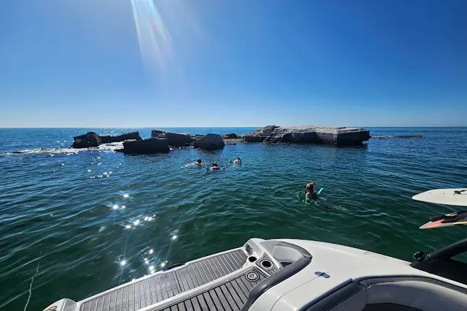 Private boat heading out across open water on a clear day