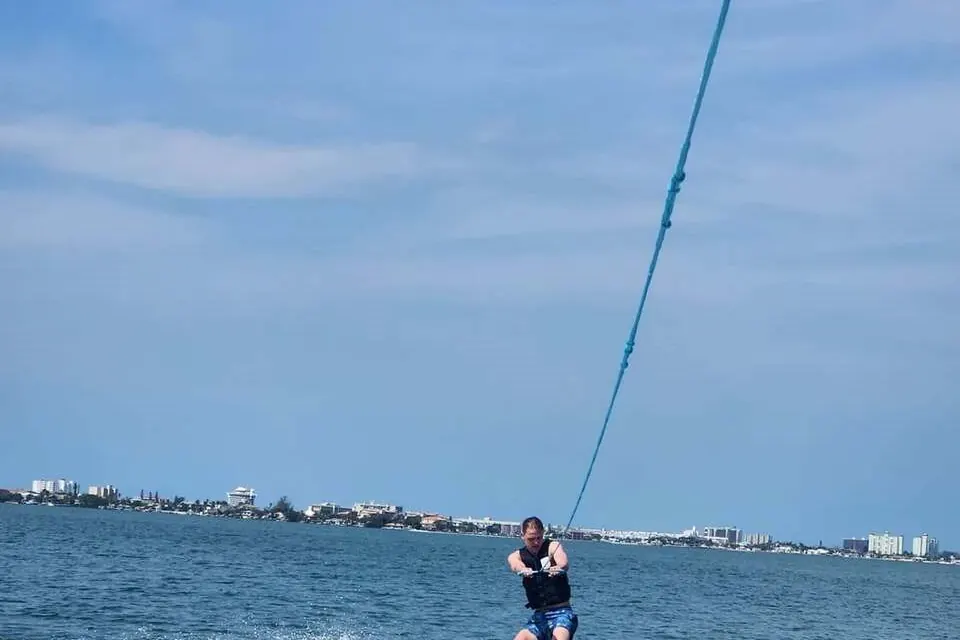 Wakeboarder jumping the wake behind a private boat