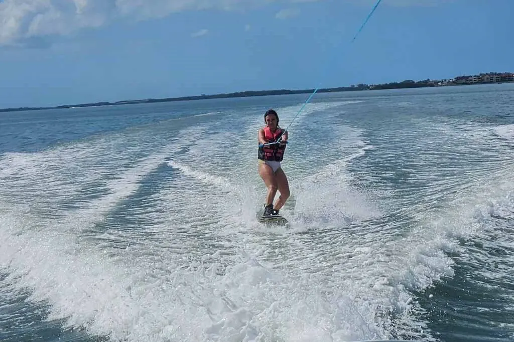 Beginner getting up on a wakeboard in calm Gulfport water