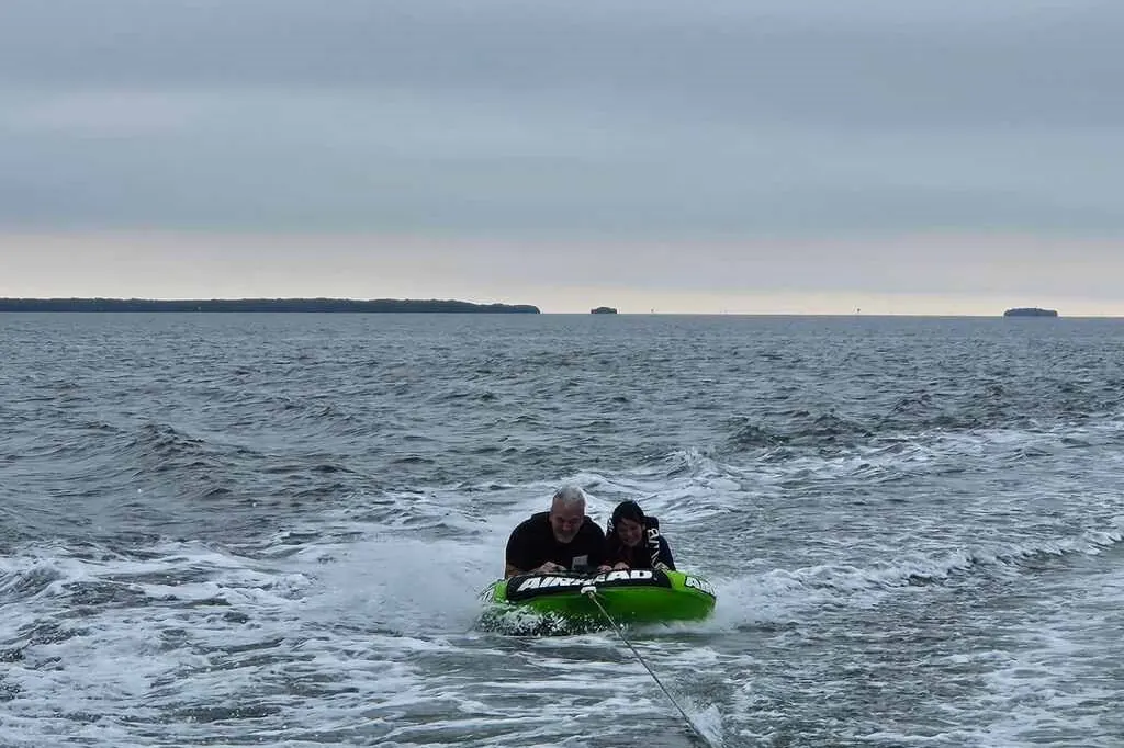 Kneeboarder riding behind a boat on an overcast day