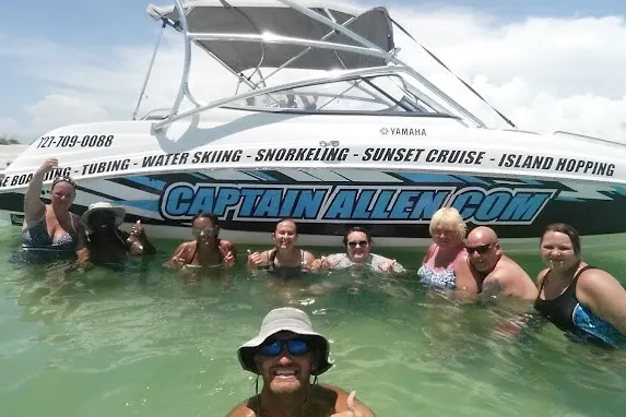 Guests wading at a shallow Tampa Bay sandbar beside a boat