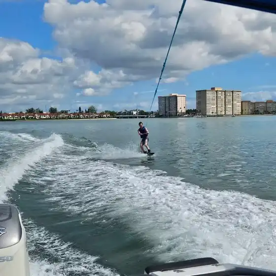 Guest standing up on a wakeboard behind a boat near Gulfport