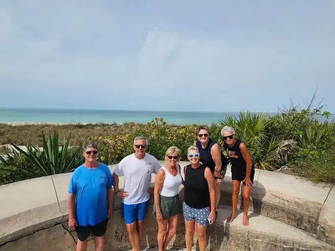 A smiling group of guests on the old fort wall at Egmont Key during a trip with Captain Allen