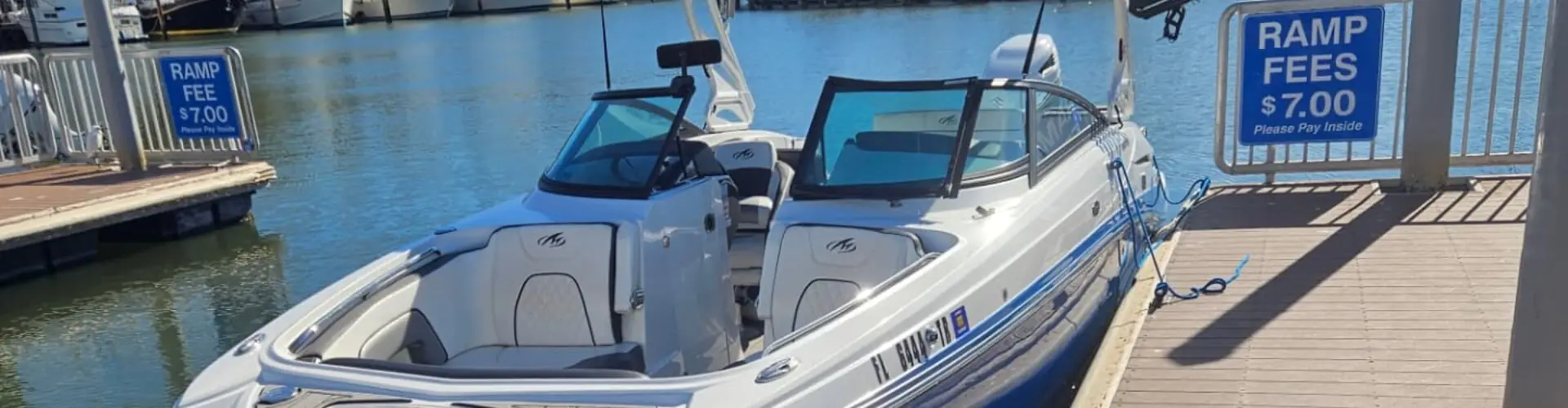 Captain Allen's white and blue Monterey bowrider tied up at the ramp dock