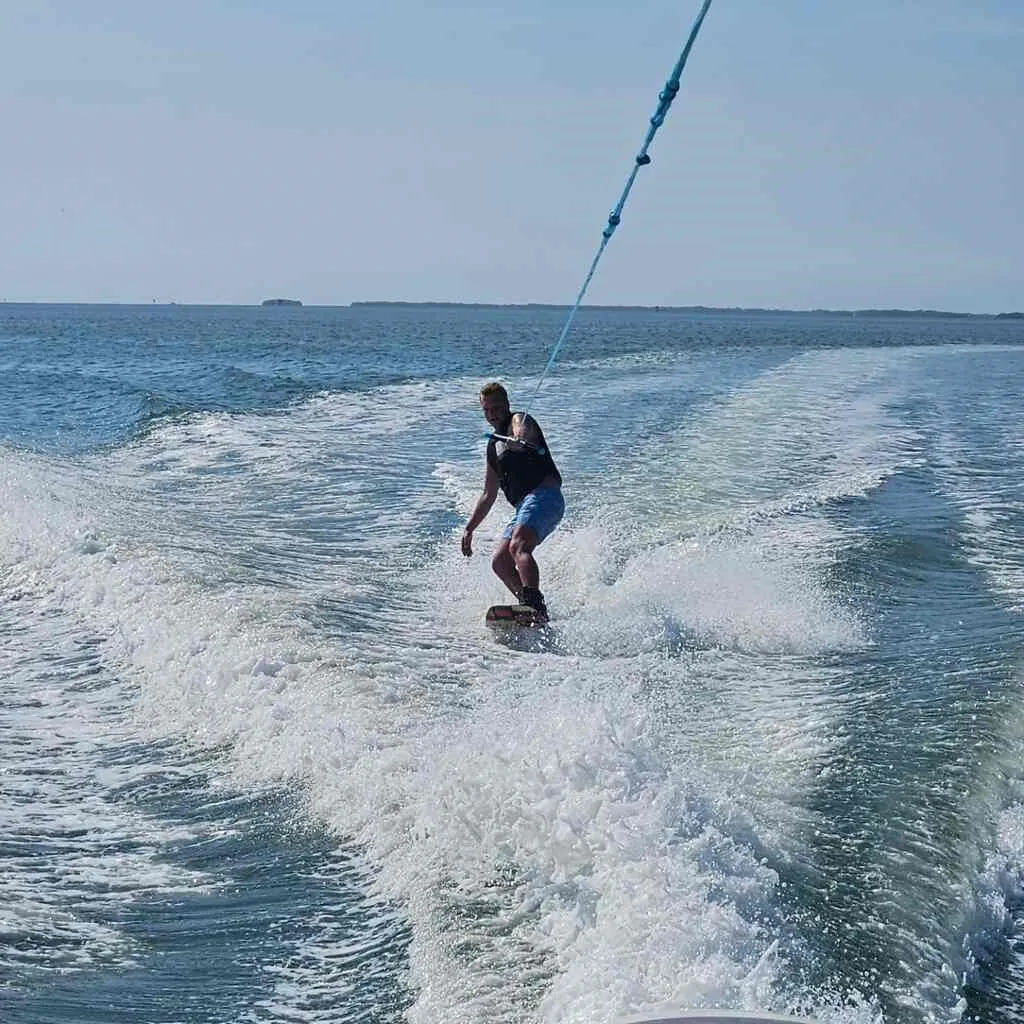 Wakeboarder crossing the wake behind Captain Allen's boat